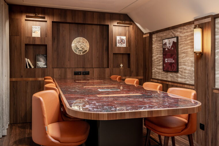 Table à manger en marbre italien entourée de fauteuils en cuir fauve